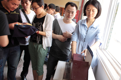 学员在巴藤南印花实验室进行特种印花实操培训——学员们在看南理环保无甲醛印花的效果